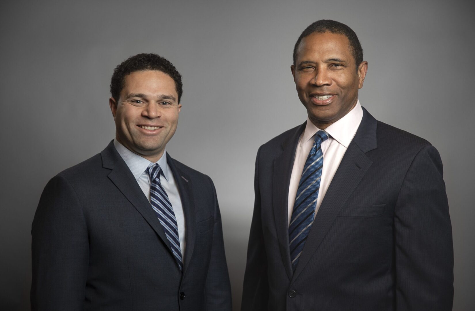 Two men in business suits posing for a photo.