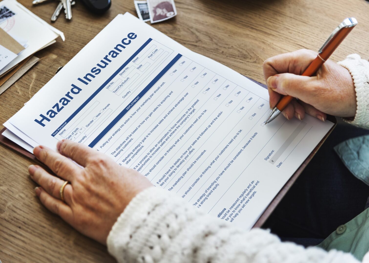 A person filling out a hazard insurance form.